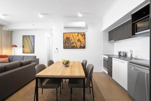a kitchen and dining room with a table and a couch at Quest Mackay on Gordon in Mackay