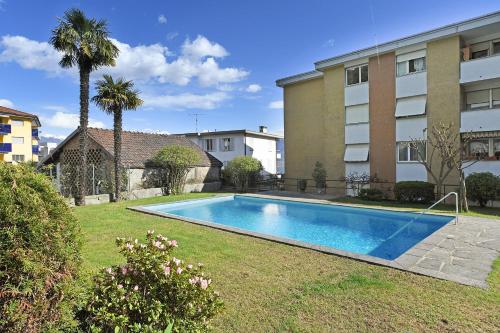 a swimming pool in a yard next to a building at Malibu46 - Happy Rentals in Minusio