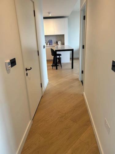 a hallway with a room with a table and a kitchen at Luxury 2 Beds Apartment in White city in London