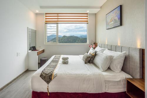 een slaapkamer met een groot wit bed en een raam bij MUONG THANH PREMIUM APARTMENTS NHA TRANG in Nha Trang