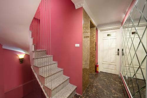 a hallway with red walls and stairs with a white door at Hanoi Backpackers Hostel Oldtown in Hanoi