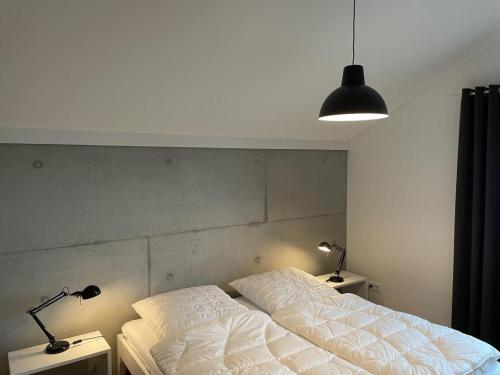 a bedroom with a bed and two lamps on tables at Modernes Architektenhaus direkt am Golfplatz Schloss Ranzow. in Lohme