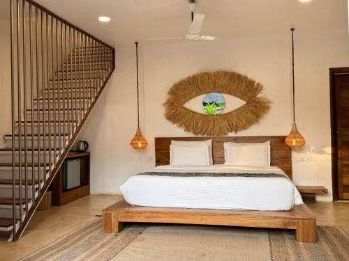 a bedroom with a bed with areath on the wall at Thalassa Beach Boutique Resort in Goa Velha