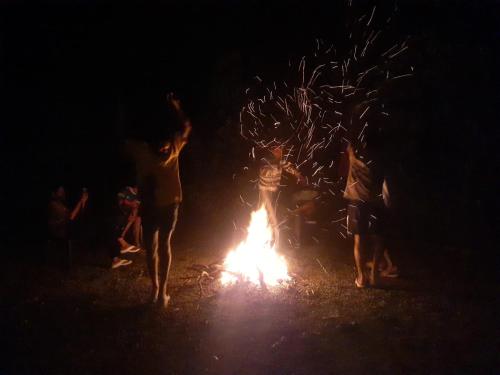 a group of people standing around a fire at night at Oasis villa in Vagamon