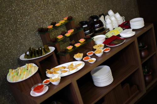 een buffet met borden en flessen wijn bij Serela Merdeka by KAGUM Hotels in Bandung