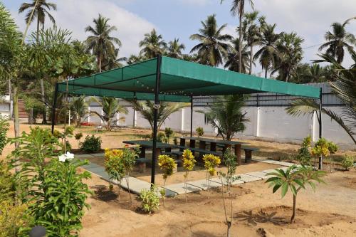 a picnic shelter with a bench in a garden at Athulya Resort -Leisure and Luxury cottages from EMBEHolidays in Kottaikadu