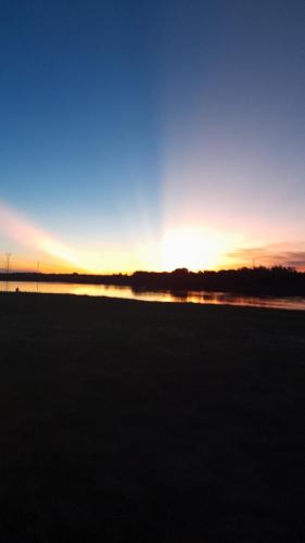 einen Sonnenuntergang über einem Feld mit einem Wasserkörper in der Unterkunft Villa Florida in Villa Florida