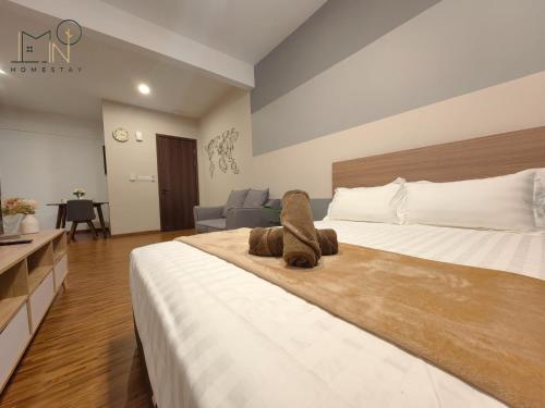 a bedroom with a large bed with a stuffed animal on it at K Avenue Modern Style Studio (5 Mins to Airport) in Kota Kinabalu