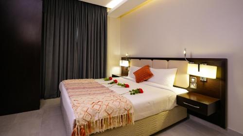 een slaapkamer met een groot bed met bloemen erop bij Saray Hotel Apartments in Koeweit
