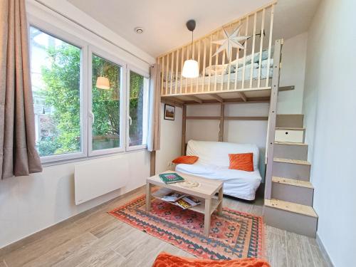um pequeno quarto com um beliche e uma mesa em Charming Tiny house with quiet garden, 15min from Paris em Saint-Maur-des-Fossés