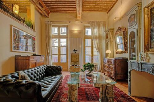 un salon avec un canapé en cuir et une table en verre dans l'établissement Maison des Arts Aix en Provence Apartment, à Aix-en-Provence