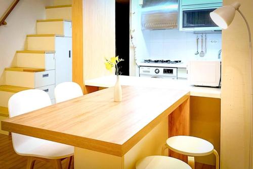 a kitchen with a wooden table and white chairs at Seohyeon station 2min Sunny house with beautiful view #Cozy place #the place of the art collector in Seongnam