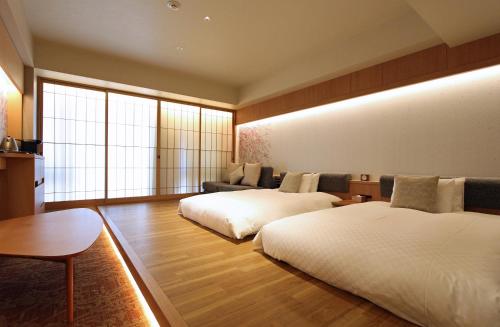 a hotel room with two beds and a couch at KAYA Kyoto Nijo Castle, BW Signature Collection by Best Western in Kyoto
