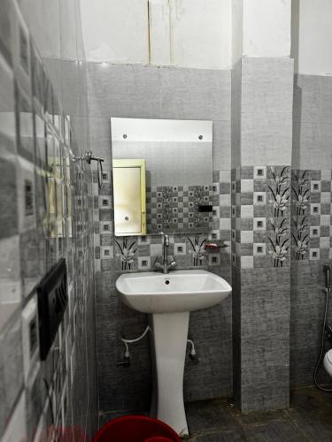 La salle de bains est pourvue d'un lavabo et d'un miroir. dans l'établissement Akash home stay, à Mussoorie
