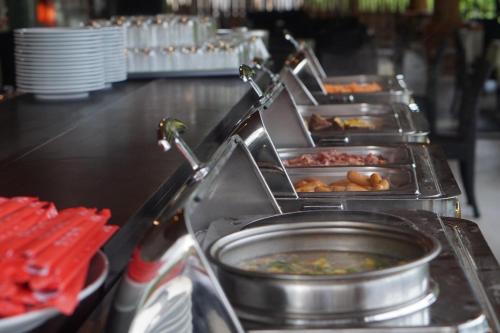 ein Buffet mit mehreren Tabletts Essen drauf in der Unterkunft Sweethome Resort & Spa Phú Quốc in Phu Quoc