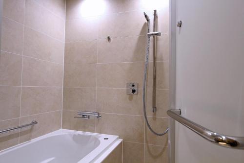a bathroom with a shower with a tub and a sink at KAYA Kyoto Nijo Castle, BW Signature Collection by Best Western in Kyoto