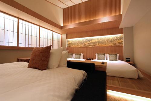 a bedroom with two beds and a large window at KAYA Kyoto Nijo Castle, BW Signature Collection by Best Western in Kyoto