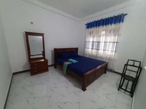 une chambre avec un lit, un miroir et une chaise dans l'établissement Sundill Green Homestay, à Tangalle