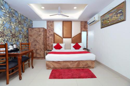 um quarto com uma cama, uma secretária e uma mesa em Hotel Mars Meg at Delhi Airport em Nova Deli