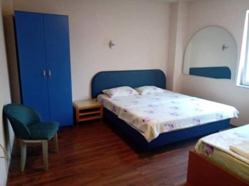 um quarto com uma cama azul e uma cadeira em Apartments Struska carsija em Struga