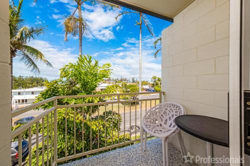 a balcony with a table and chairs and palm trees at Superior Studio 17 Endeavour in Emu Park