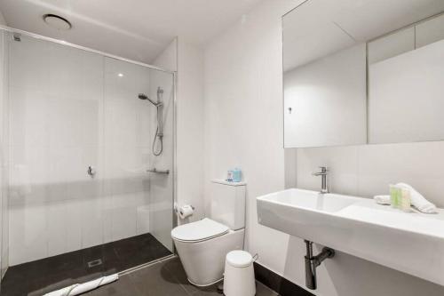 a white bathroom with a toilet and a sink at Southbank Bella - New Listing in Melbourne