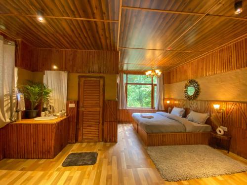 a bedroom with two beds in a room with wooden walls at Whoopers Boutique Resort Jibhi in Jibhi