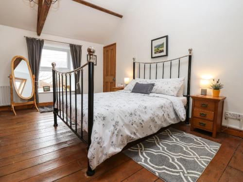 a bedroom with a black and white bed and a mirror at Wayside Cottage in Consett