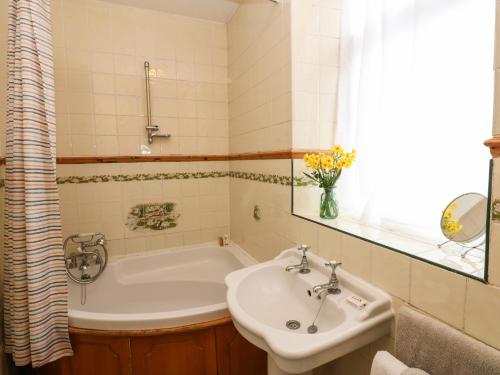 a bathroom with a sink and a bath tub at Wayside Cottage in Consett