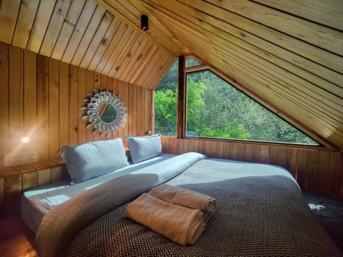 a bedroom with a large bed in a cabin at Whoopers Boutique Resort Jibhi in Jibhi