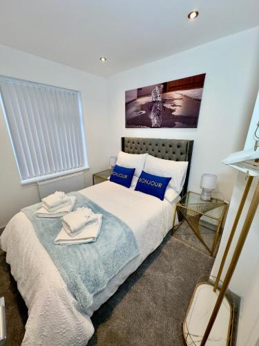 a bedroom with a bed with blue and white pillows at Clarendon House - Hot Tub in Lincolnshire