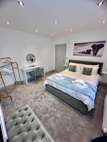 a bedroom with a large bed and a desk at Clarendon House - Hot Tub in Lincolnshire