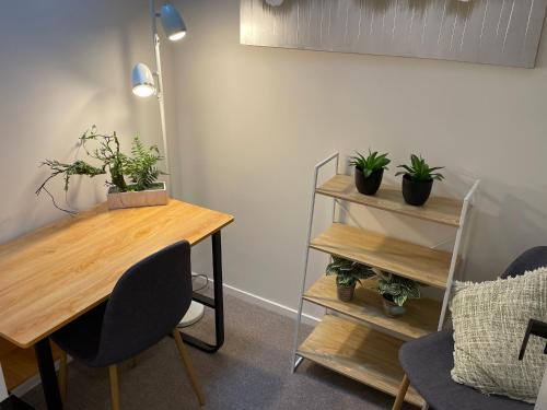 a room with a table and plants on a wall at Flat Bush Holiday Accomodation in Auckland