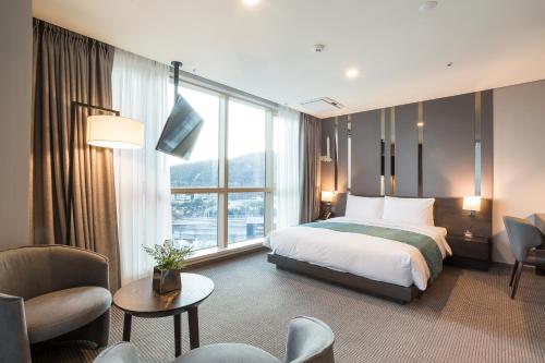 a hotel room with a bed and a large window at Centum Prime Hotel in Busan