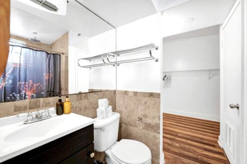 y baño con aseo, lavabo y ducha. en Hispaniola Apartments Part of the Oasis Casita Collection, en Miami Beach