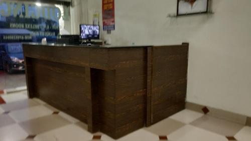 a wooden counter in a room with a tv at Hotel Avinash Inn Lodging in Nashik