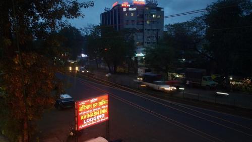 a sign on the side of a city street at night at Hotel Avinash Inn Lodging in Nashik