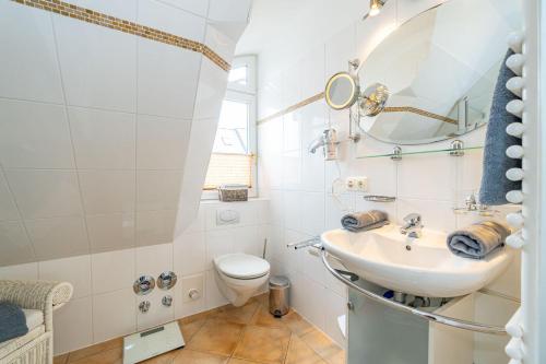 a bathroom with a sink and a toilet at WILDENTE-App-7 in Wenningstedt
