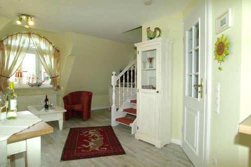 a living room with a staircase and a stair case at WILDENTE-App-7 in Wenningstedt