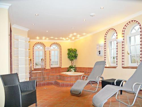 a waiting room with chairs and a tub and windows at WILDENTE-App-7 in Wenningstedt