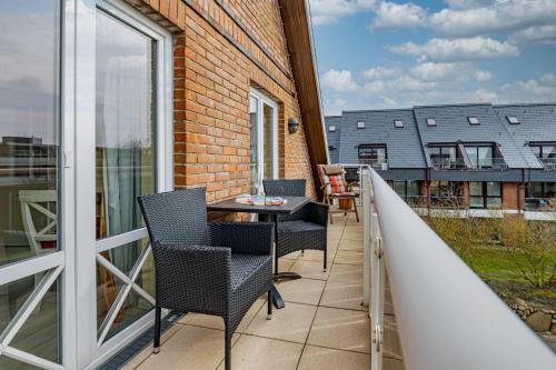 a balcony with a table and chairs on it at WILDENTE-App-7 in Wenningstedt
