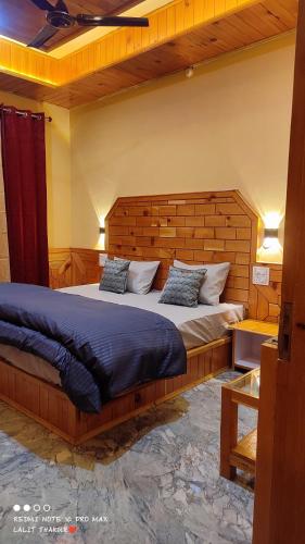 a bedroom with a large bed with a wooden headboard at Wood packers in Kasol