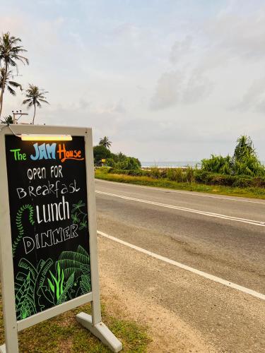 a sign sitting on the side of a road at The Jam House in Ahangama