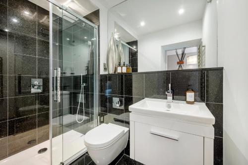 a bathroom with a toilet and a shower and a sink at Aircon 2 Bedr, 3 Beds, 2 Bath Covent Garden, Subway in London