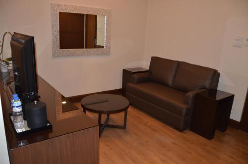 a living room with a couch and a television at Hotel Monticello Tagaytay in Tagaytay