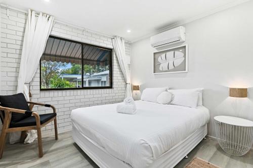 Un dormitorio blanco con una cama grande y una ventana en Oceanview on Dudley, en Woodgate