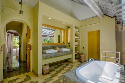 a bathroom with a tub and two sinks at Space Villas Bali in Seminyak