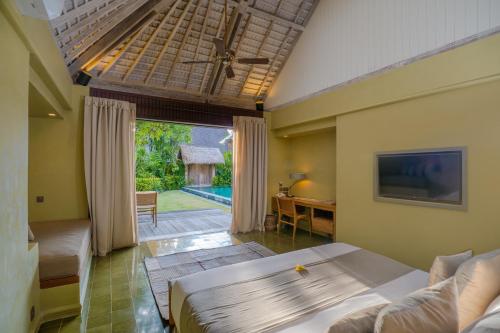 a bedroom with a bed and a view of a pool at Space Villas Bali in Seminyak
