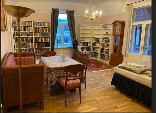 a room with a table and a bed and bookshelves at Villa Internationals in Oslo