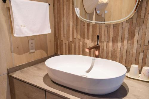a white sink in a bathroom with a mirror at Hanare Yado Yosizumi in Ito